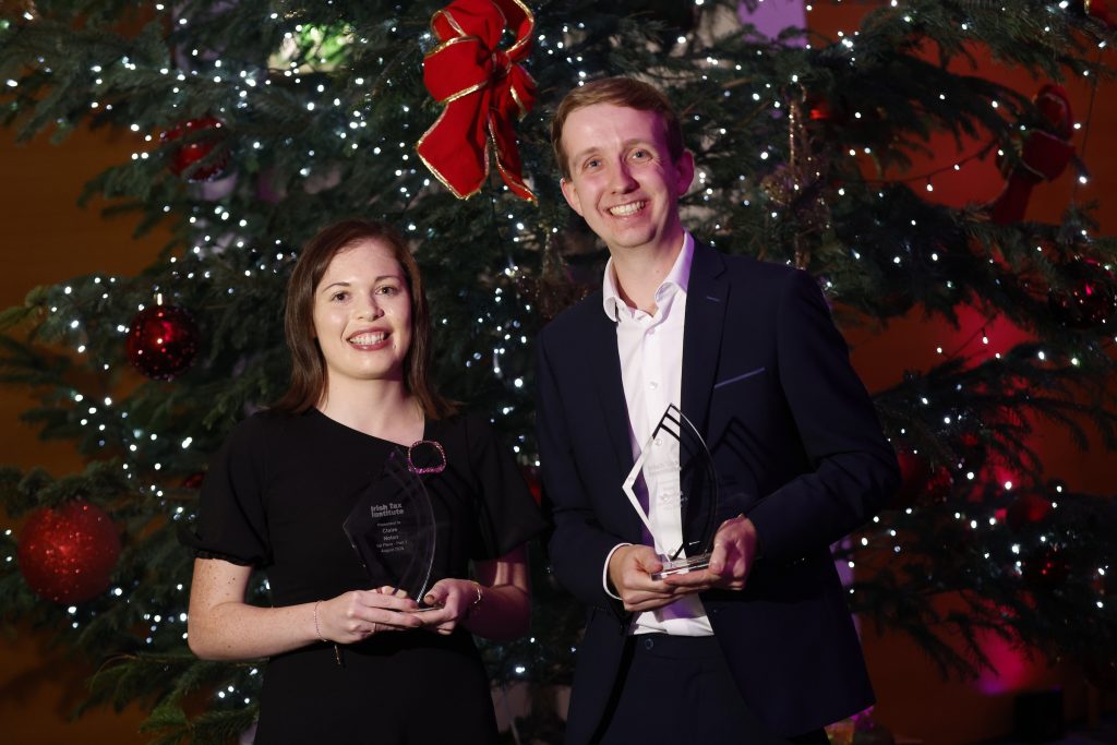 Claire Nolan and Sam Totterdell with their 1st place awards in front of a Christmas tree.
