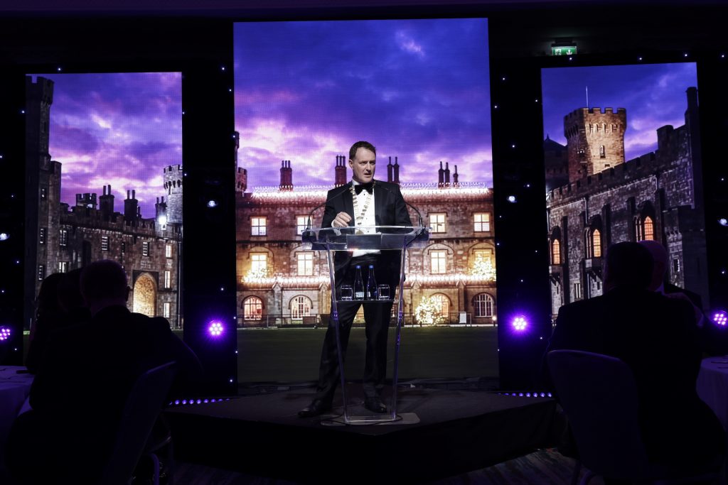 Irish Tax Institute President, Shane Wallace, delivering his speech at Annual Dinner 2026. Behind Shane is a photo of Kilkenny Castle.