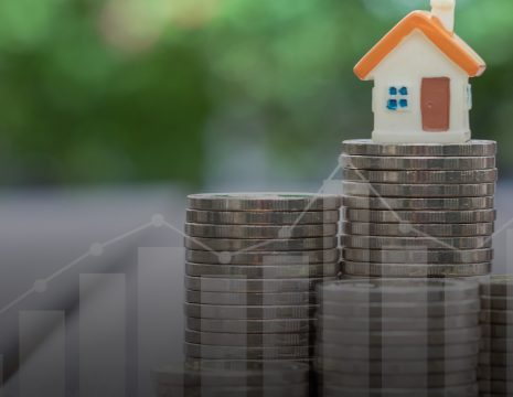 The Cert in Capital Taxes banner is of a small house figurine with an orange roof sits on top of a stack of coins.