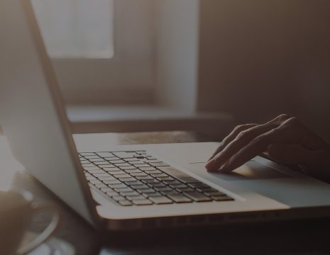 Photo of a laptop with a hand on the touchpad doing their eWHT.